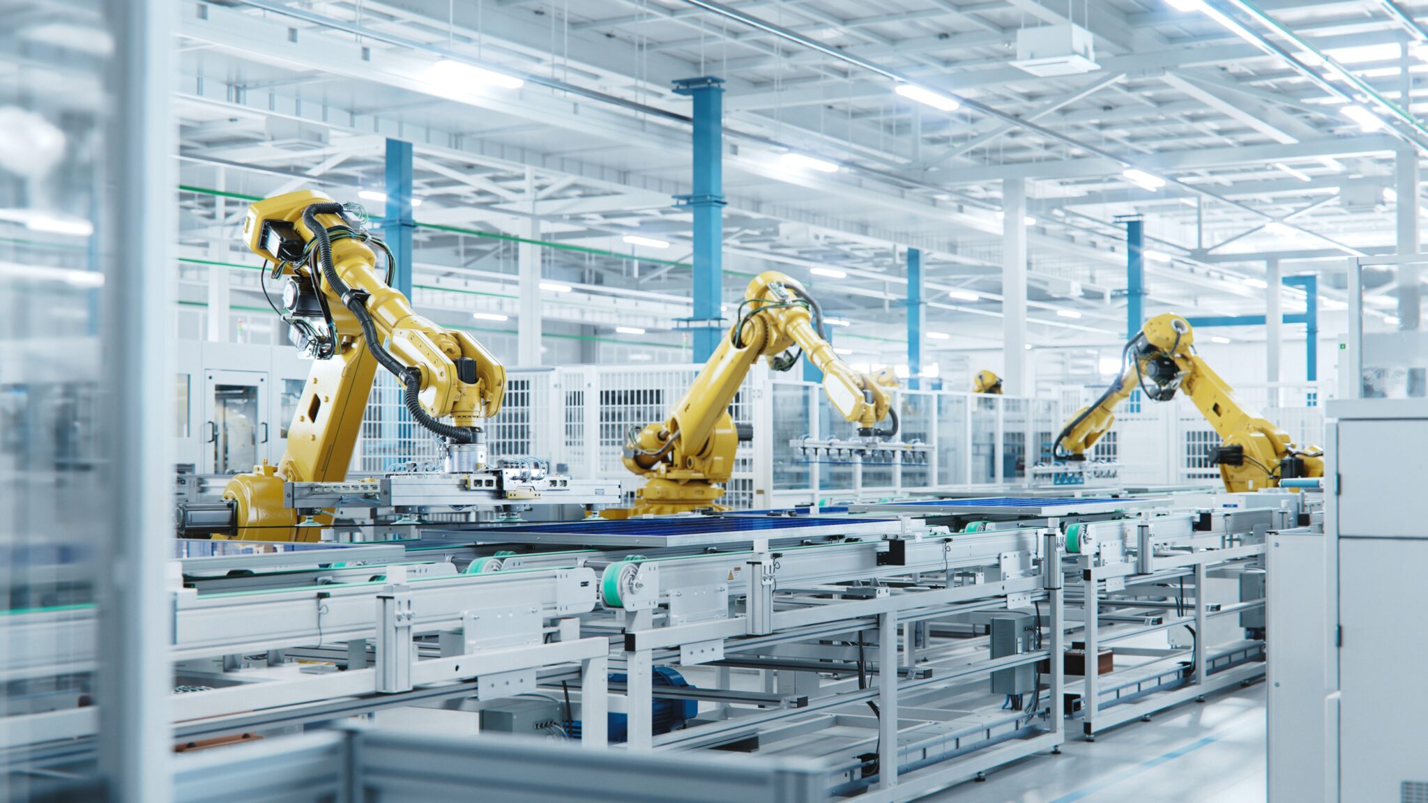 large production line with industrial robot arms at modern bright factory. solar panels are being assembled on conveyor. automated manufacturing facility